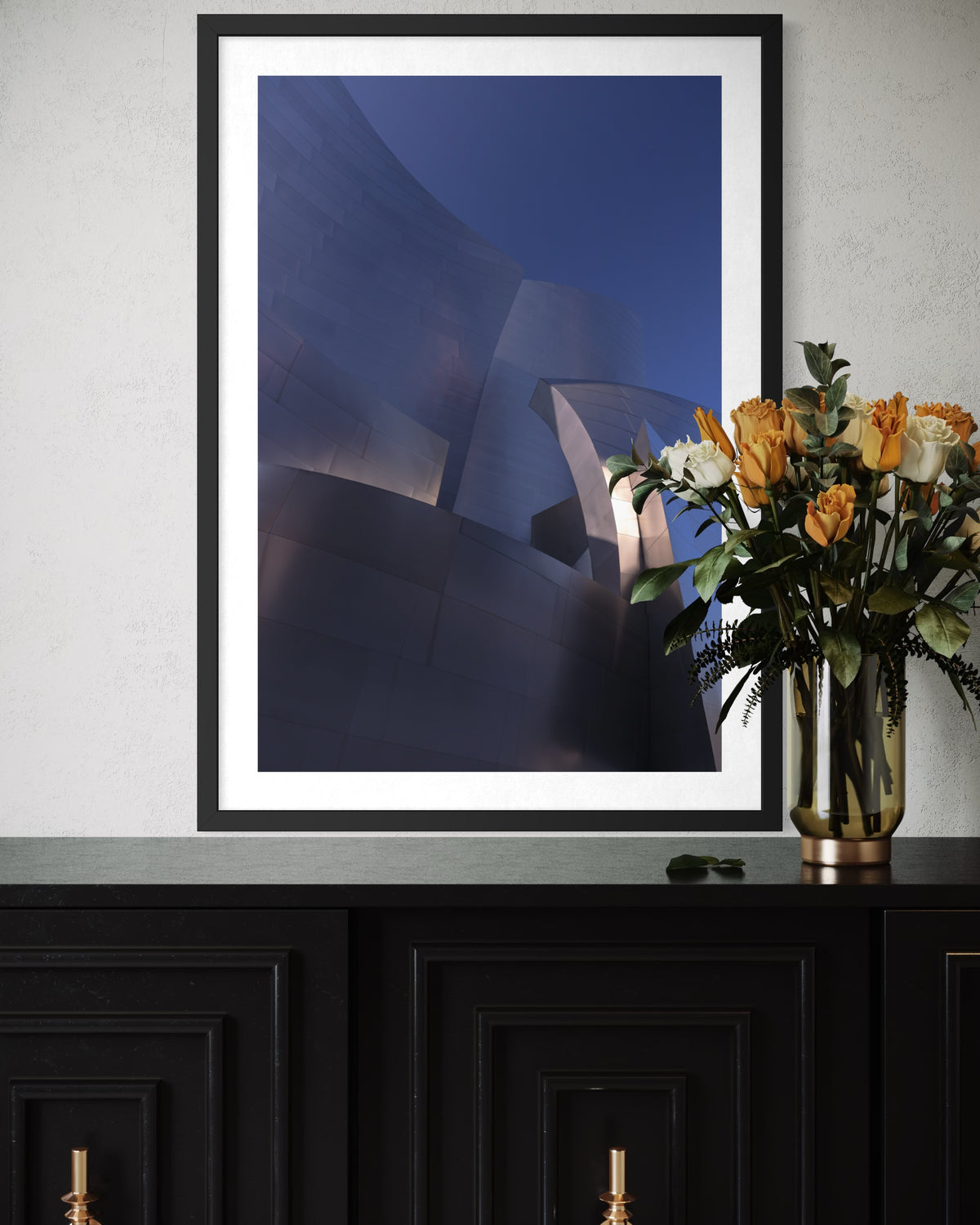 Abstract Blue Gehry photo taken in Los Angeles, displayed above a black cabinet with orange flowers in a vase.