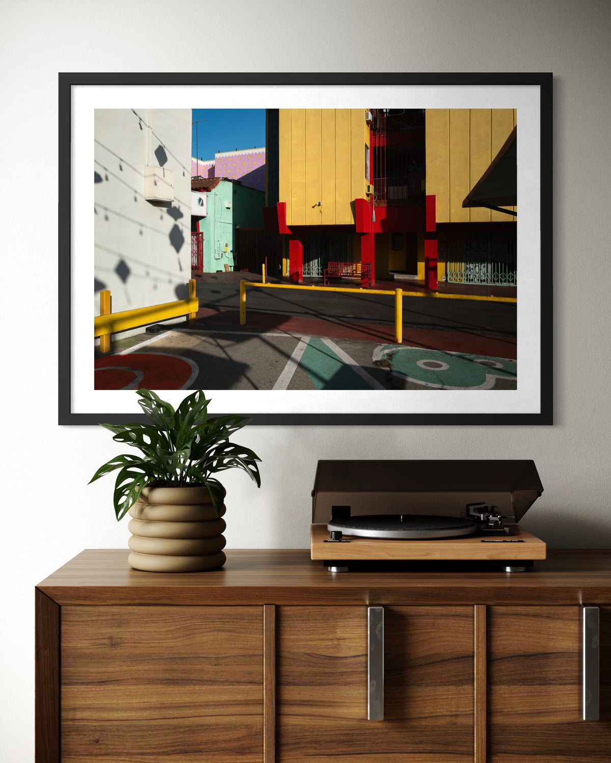 Framed “Chinatown Study” print displayed above a record player and potted plant in a living space.