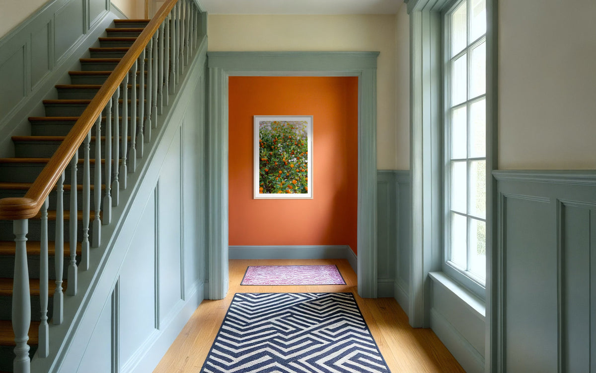 Zigzag rug, blue-green trim, Citrus Summer accent wall, and framed abstract art in hallway.