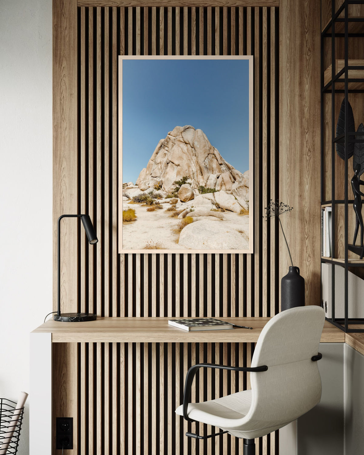 Framed “Desert Form” Rocky Mountains photo displayed on a desk against a slatted wood wall with lamp.
