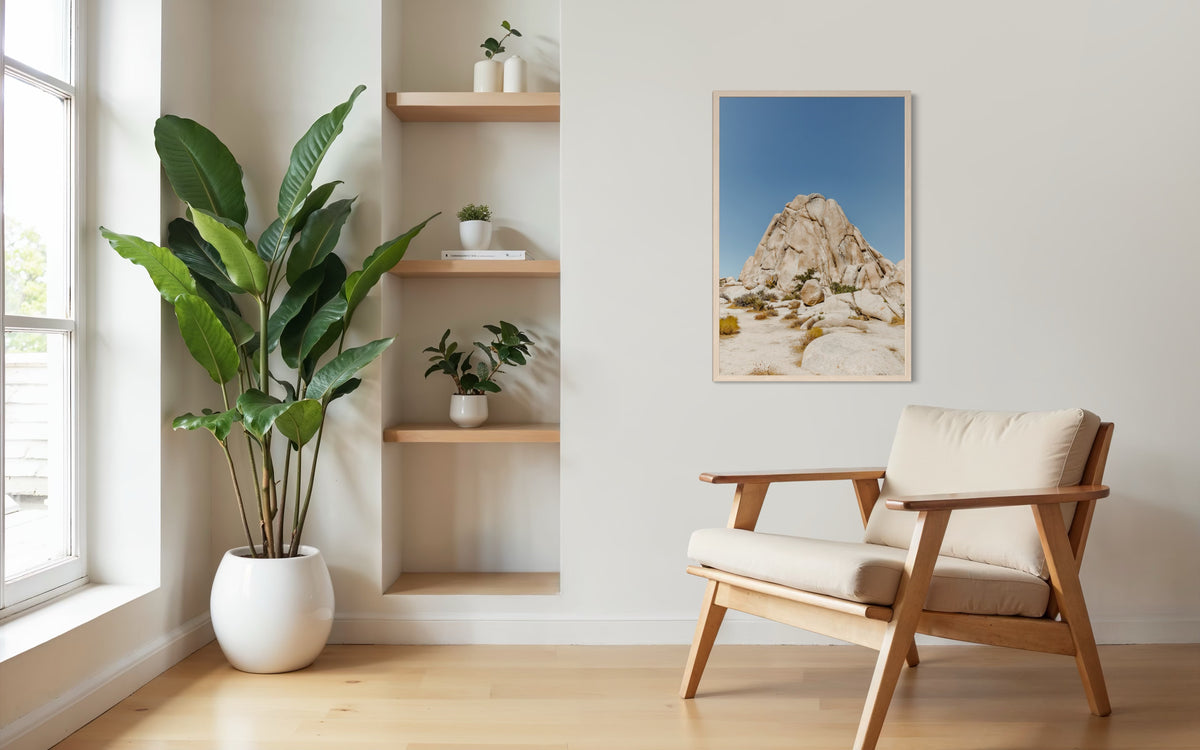 Living room with potted plant, wooden chair, and Desert Form art print of a rock formation on the wall.