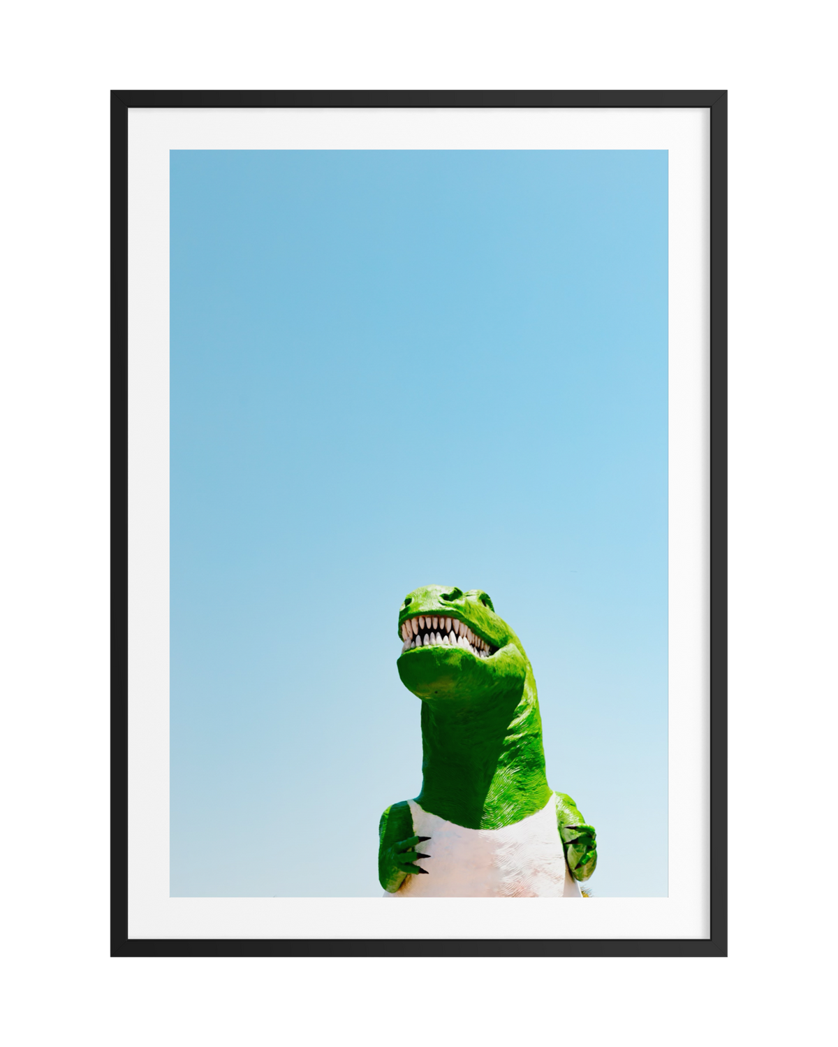 Large dinosaur statue with sharp teeth under a clear California sky, centered in a black frame.