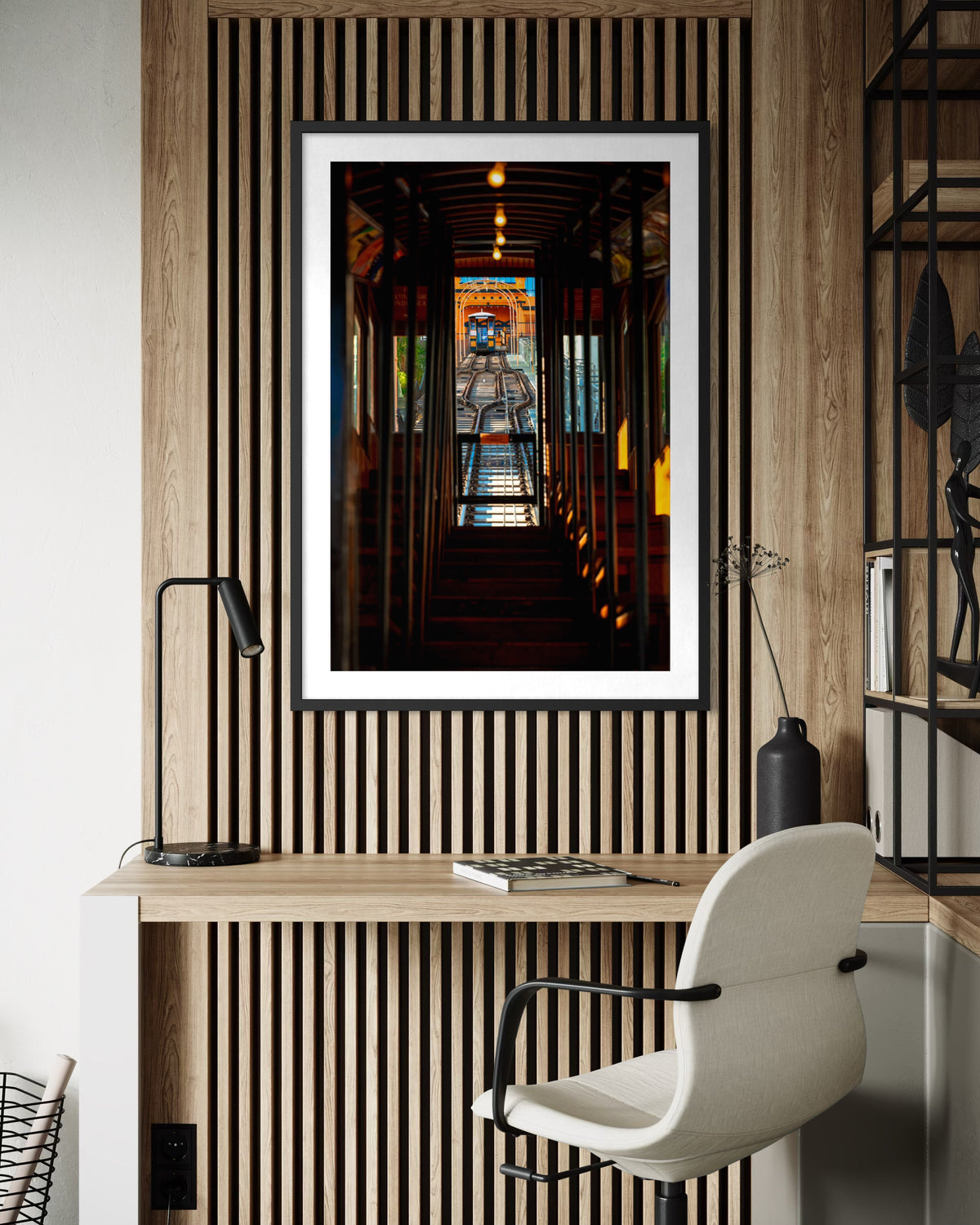 Framed “DTLA Funicular” photo of a Los Angeles railcar hangs above a wood desk and chair in a modern office.