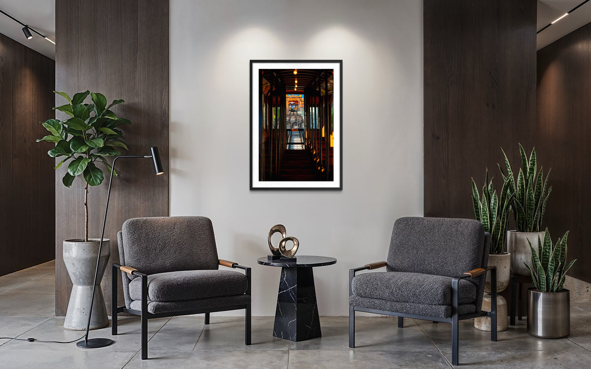 Gray armchairs and a black table with DTLA Funicular artwork in a Los Angeles lounge.