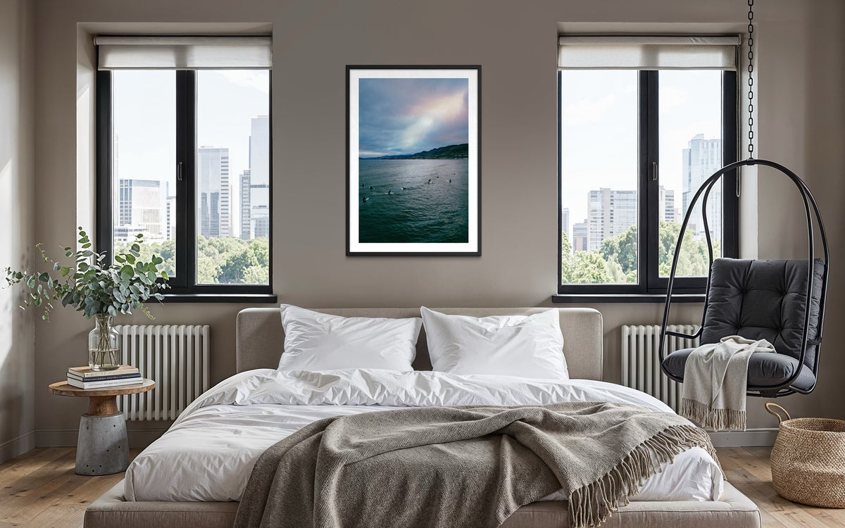 Framed “Ethereal Sky, Pismo Beach” photo above bed in a modern room with large windows and city skyline view.