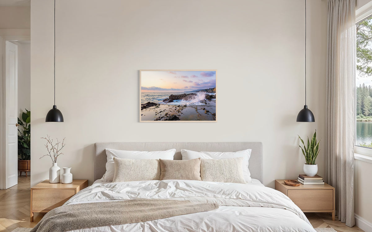 Bedroom with leafy plants and “Evening Splash” art print above the bed, evoking a Laguna Beach summer evening.
