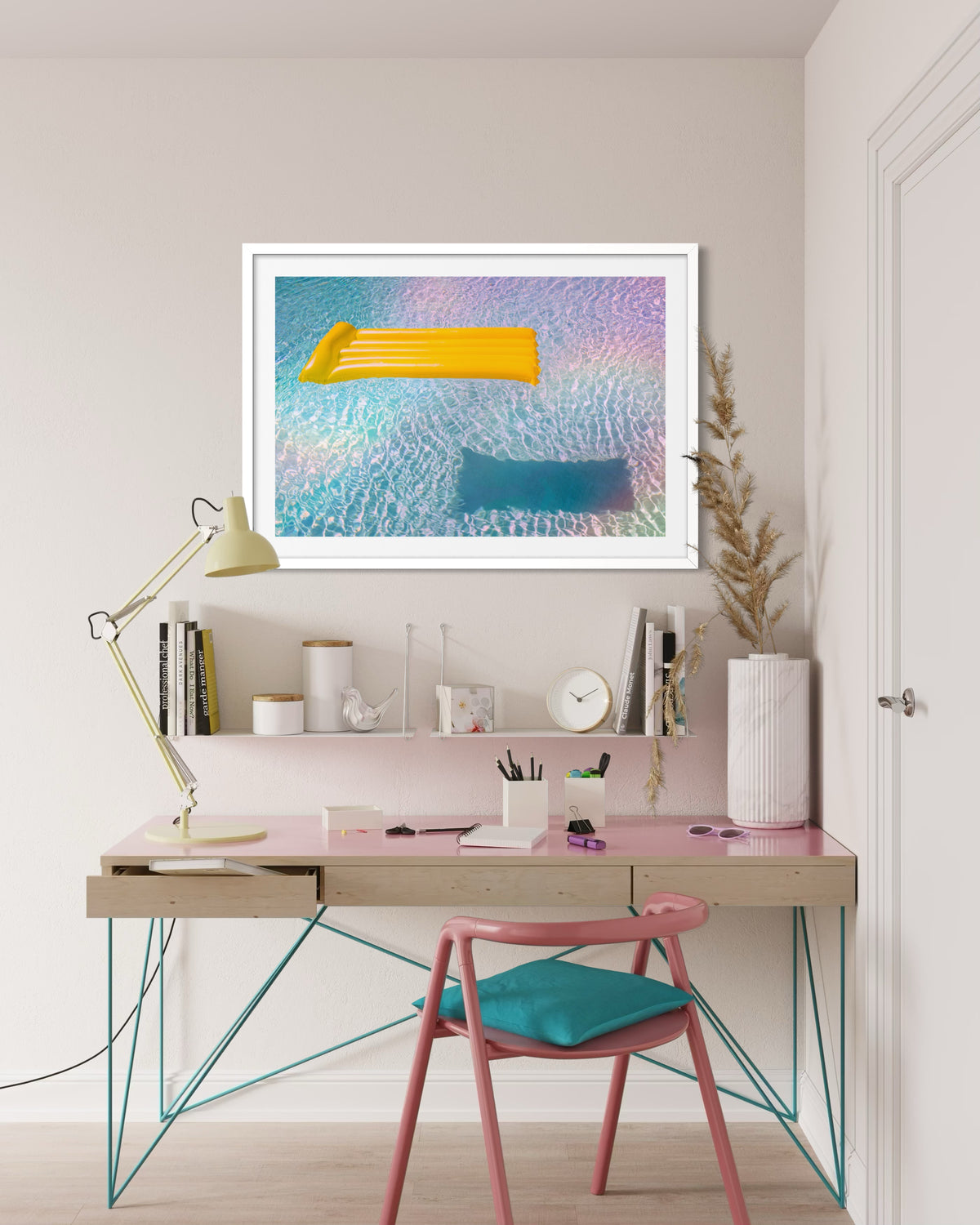 Modern desk with pink chair, lamp, and “Floating Through Summer” pool float wall art.