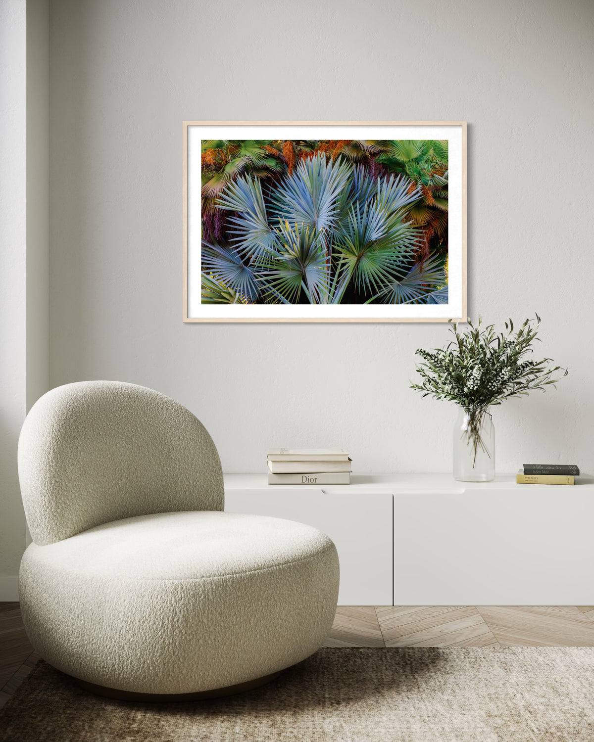 Modern living room featuring a round chair, Footstool Palm, sideboard, vase, and palm fronds wall art.