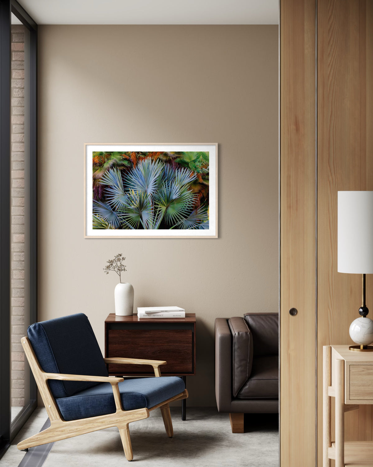 Blue chair, brown sofa, wooden table, and Footstool Palm in a modern living room.