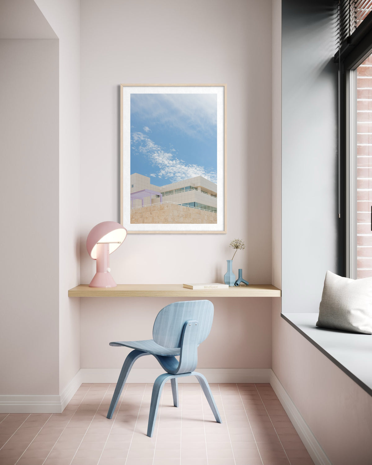White walls, blue chair, pink lamp, Getty Center II art on the wall in a pastel-themed room.