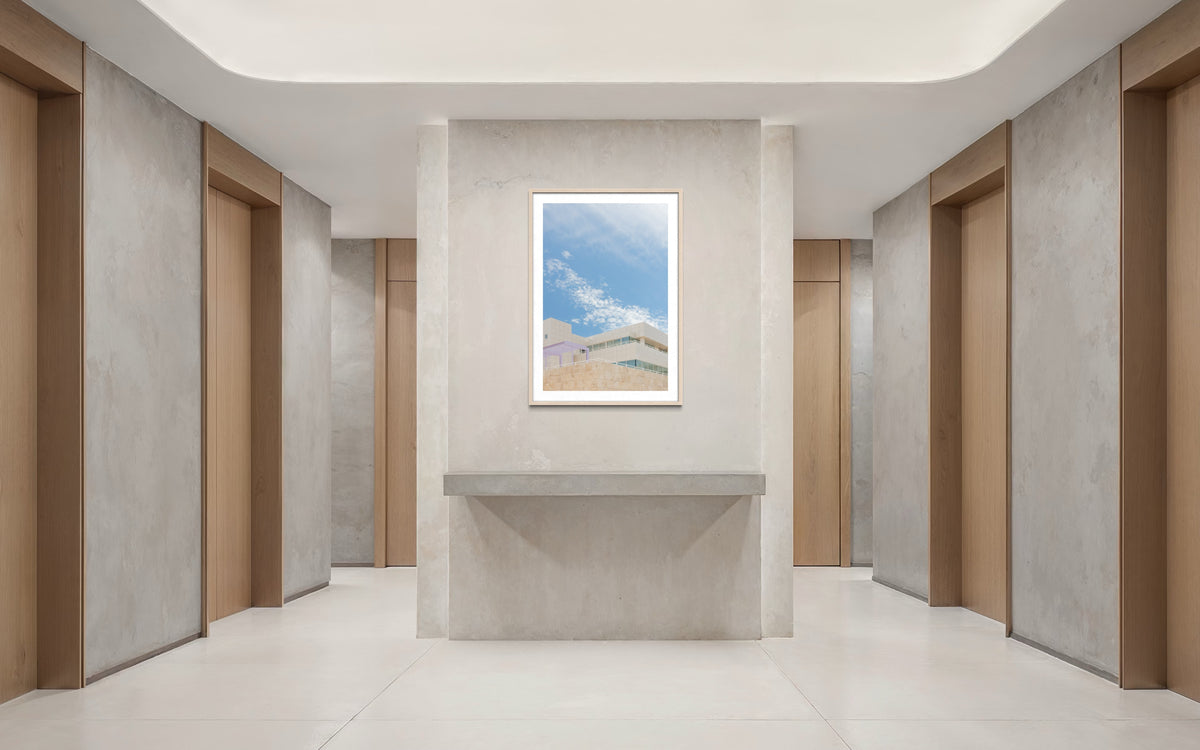 Elevator lobby with six wooden doors, concrete walls, and white architectural details at Getty Center II.