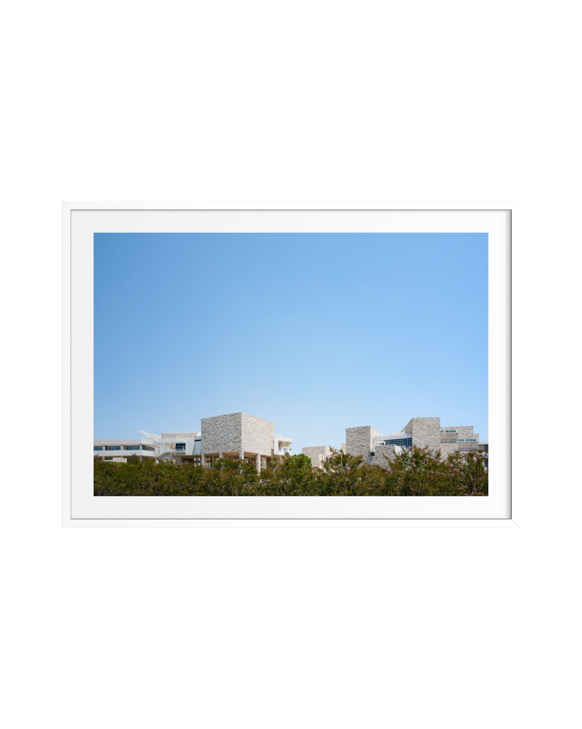 Modern travertine buildings at Getty Center, Los Angeles, set against blue sky and green trees.