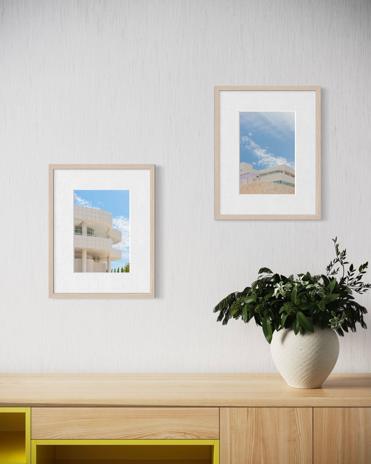 The Getty Center photograph displayed above a wooden cabinet and potted plant on a white wall.