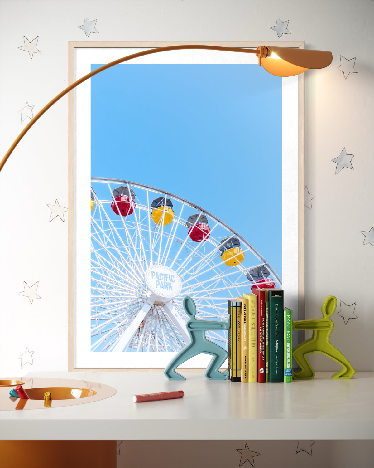 Framed “Going in Circles” print on a desk with books, a lamp, and décor items arranged nearby.