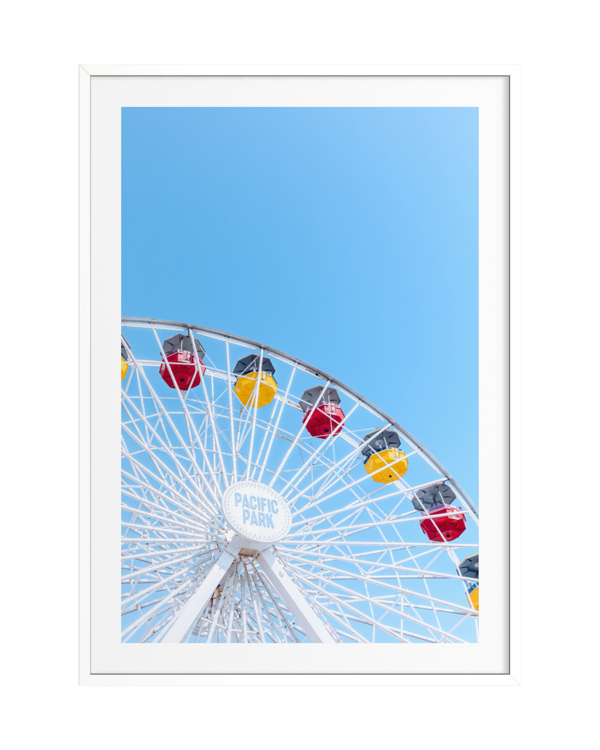 Ferris wheel section with colorful passenger cars against blue sky, photographed at a summer fairground.