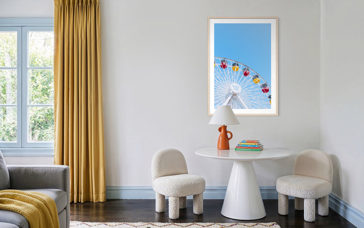Going in Circles“ photo displayed above a round table with books and two white chairs in a bright living room.