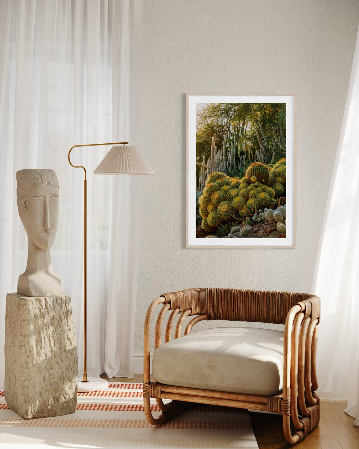 Rattan chair, statue, lamp, and Golden Barrel Cactus art framed by sheer curtains in a cozy corner.