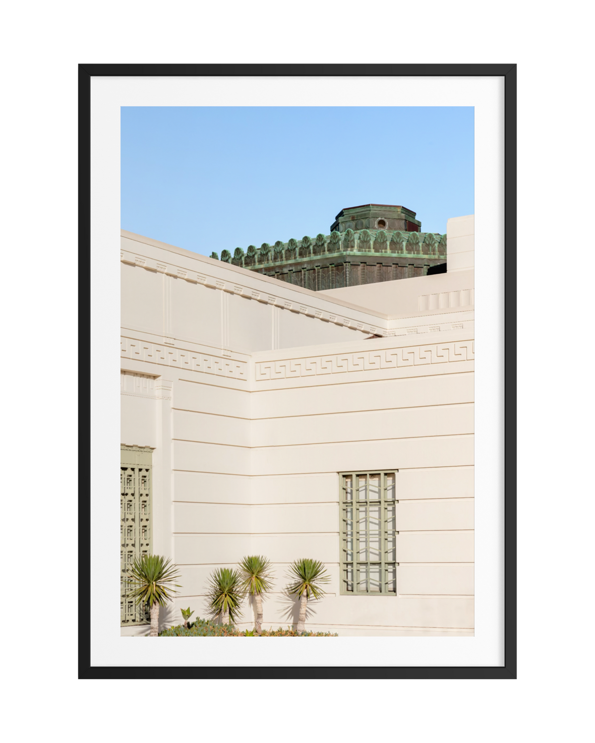 Griffith Observatory’s white Art Deco structure with green dome, palms, and blue sky in Los Angeles.
