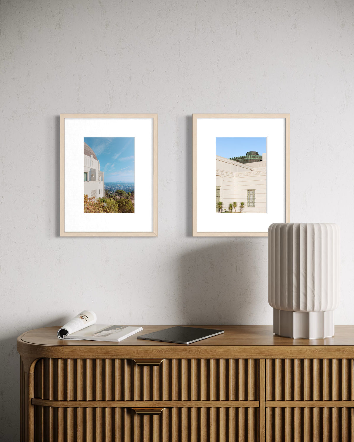 Griffith Observatory print displayed above a wooden sideboard with lamp, papers, and tablets; Los Angeles location.