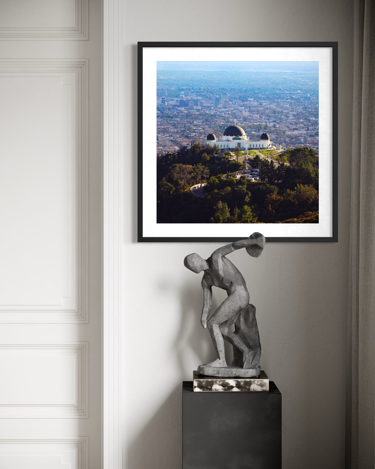 Statue near Griffith Observatory with Los Angeles cityscape in the background.