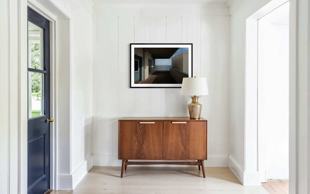 Ocean View photograph from Harbor Office hangs in a hallway with white walls and a closed dark door.