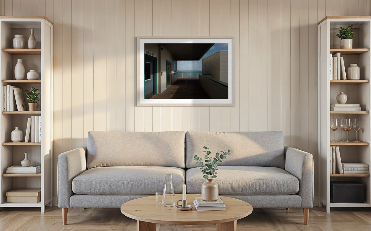 Beige sofa, round table, bookshelves, and wall art in the Harbor Office Ocean View interior on the Pacific coast.