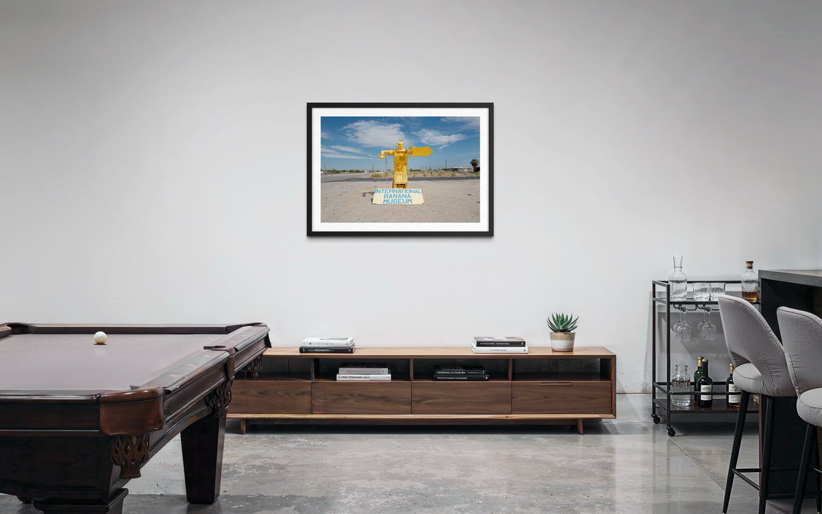 Living room with pool table, TV console, bar, and International Banana Museum print on the wall.