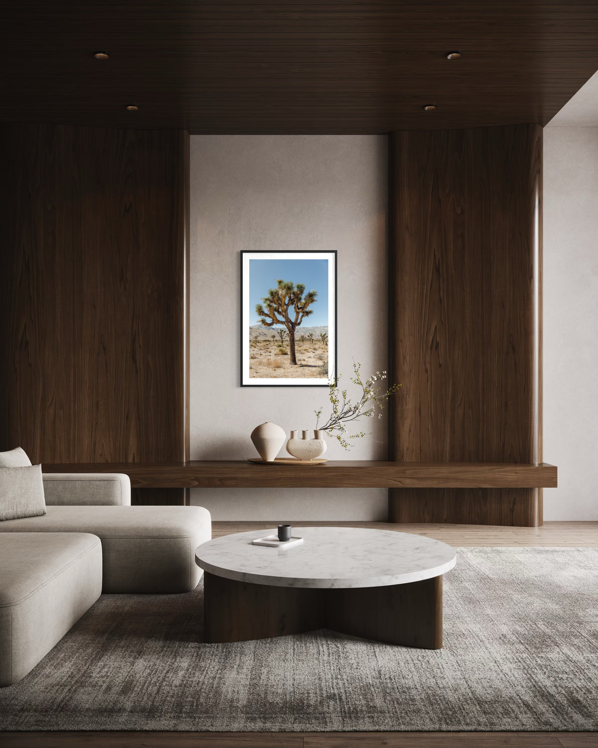 White sofa and marble table in wood-paneled living room, Joshua Tree III photography print on the wall.