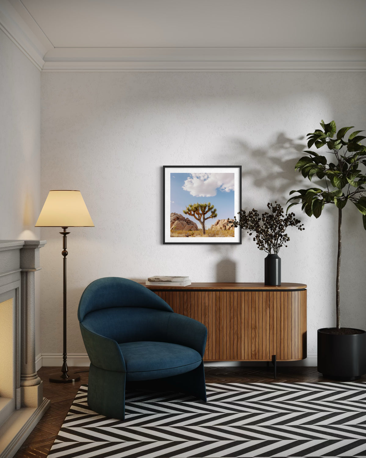 Framed Joshua Tree IV landscape print above a blue chair, floor lamp, sideboard, and potted plant in a living room.