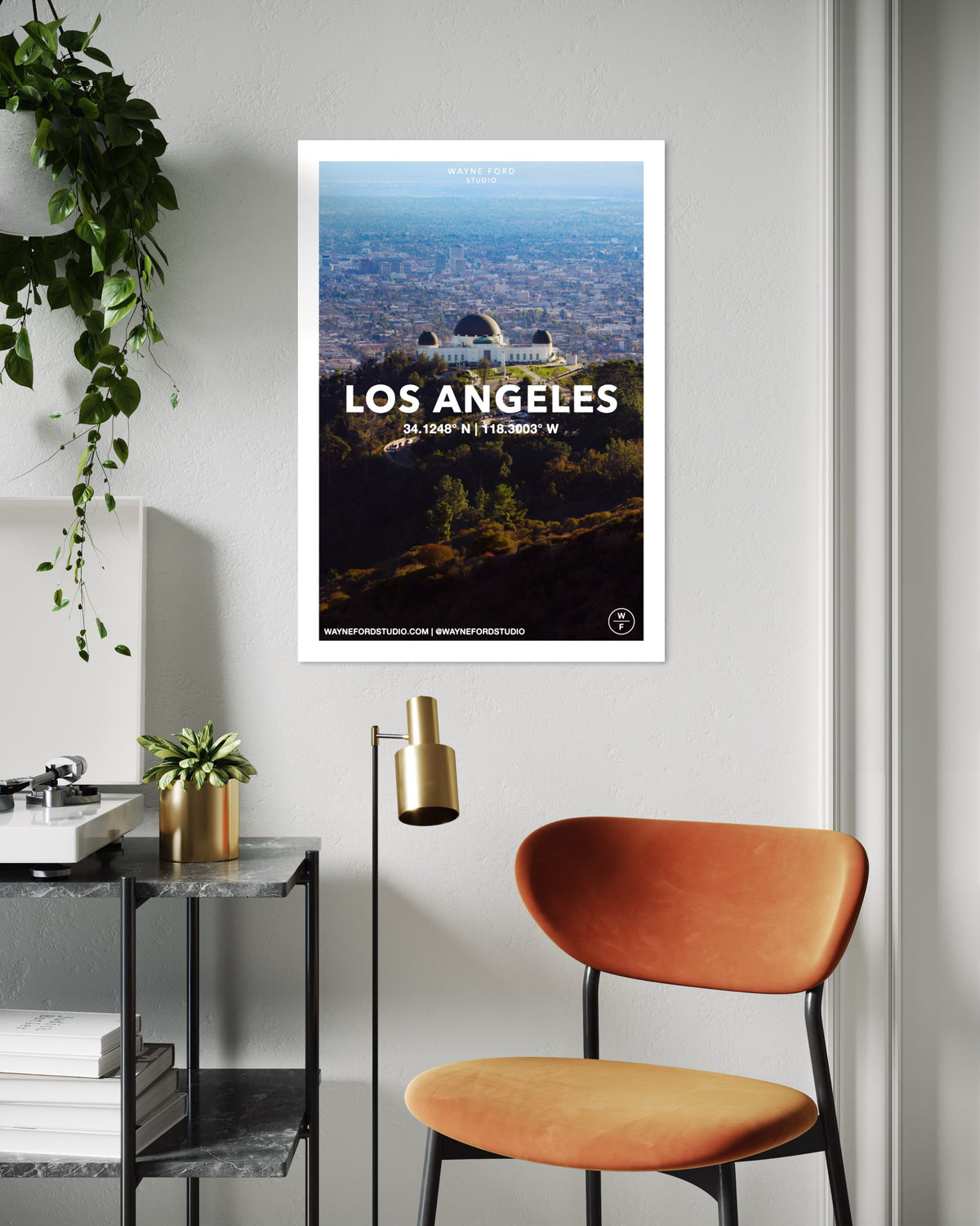 Los Angeles cityscape poster with coordinates, displayed above a desk and orange chair.