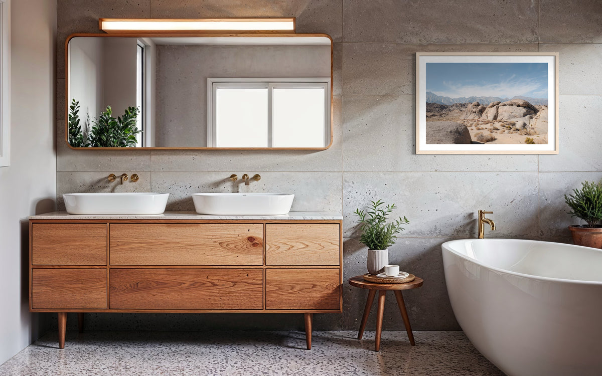Bathroom with wooden vanity, double sinks, plants, and a Lone Pine landscape photograph on the wall.