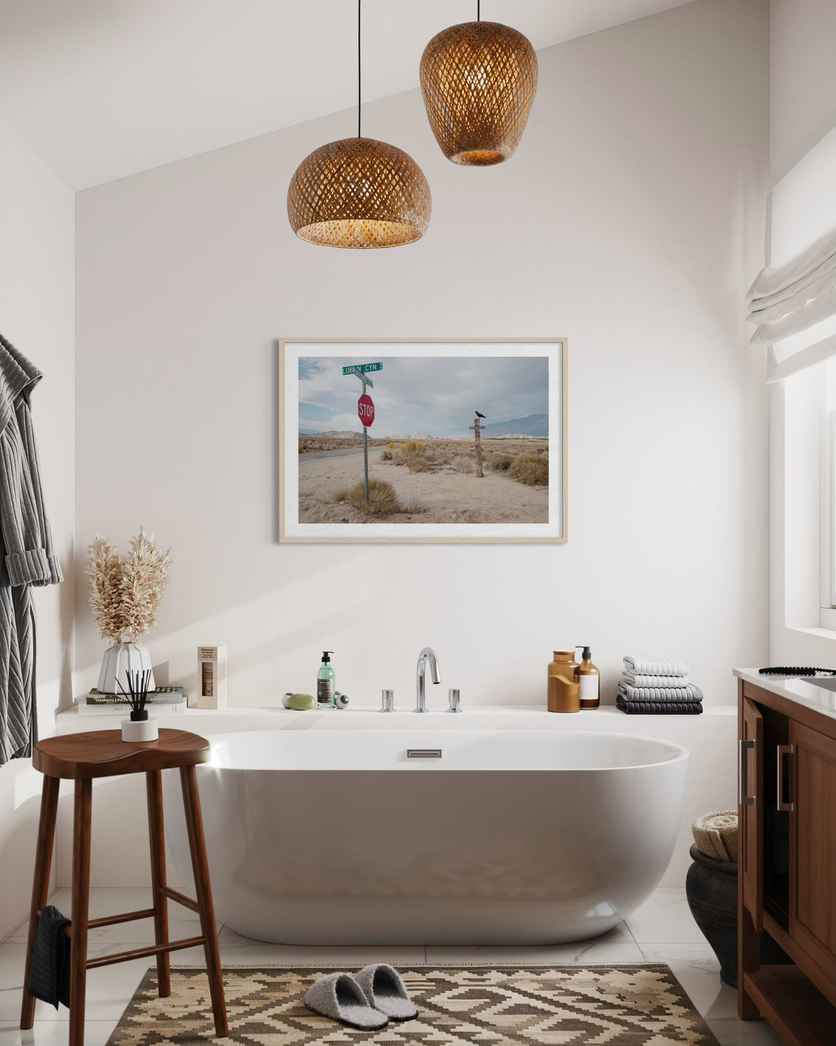White bathtub and woven accents in a bathroom, with ‘Lone Pine Sentinel’ wall art of California’s Eastern Sierra above.
