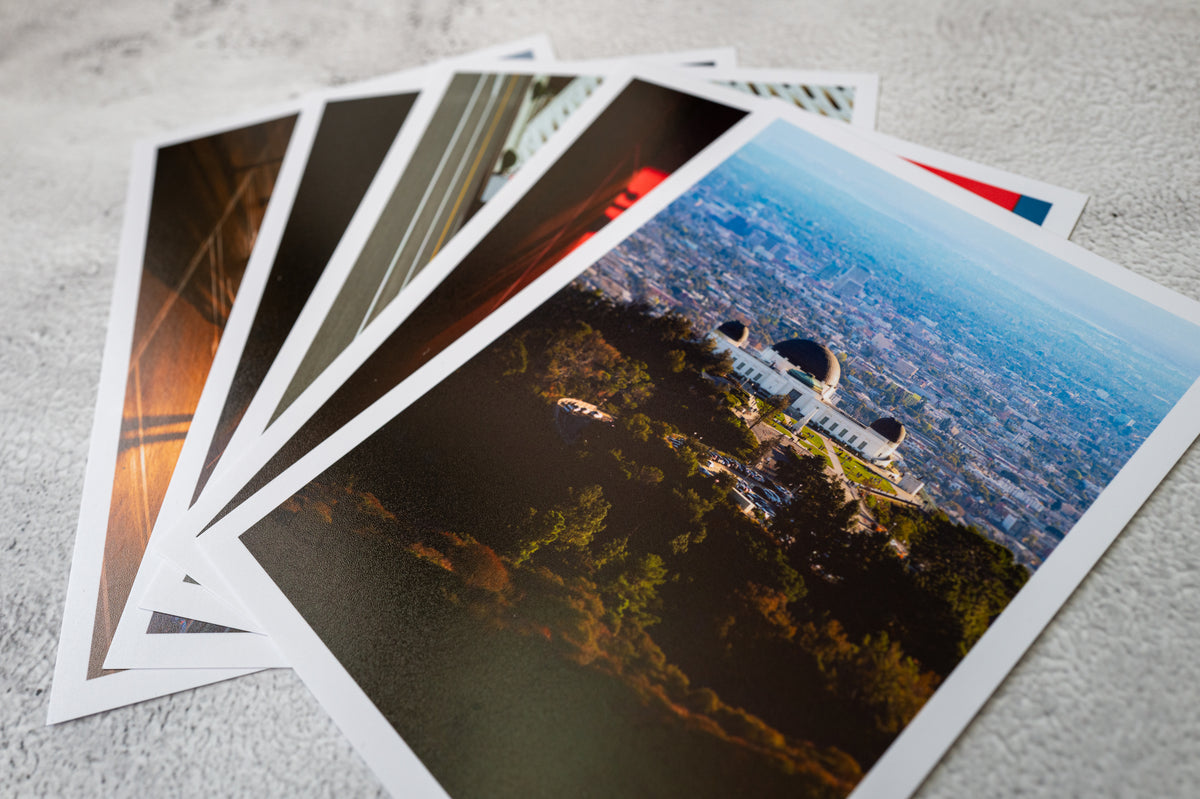 Stack of Los Angeles cityscape and Griffith Observatory prints set against a gray background.