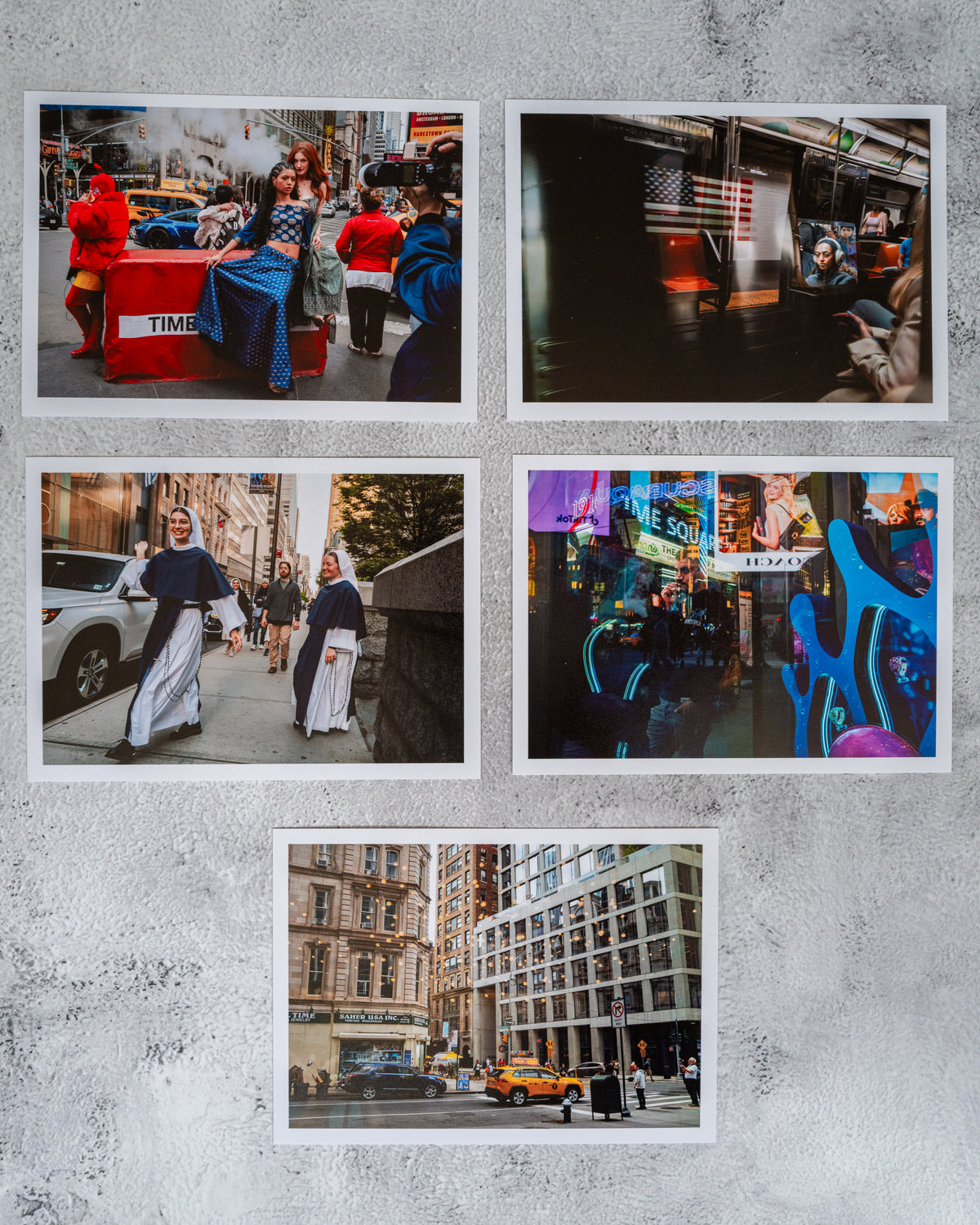 Set of five vibrant New York City street, subway, and night photos arranged on a gray surface.