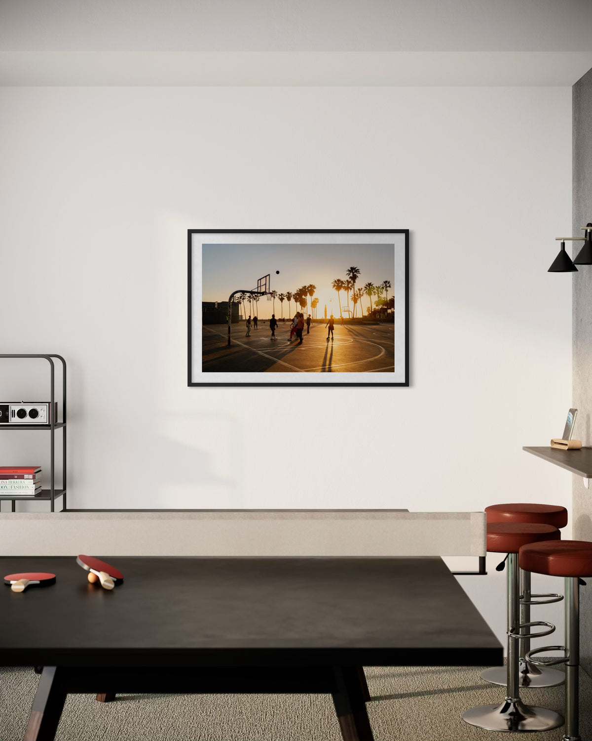Ping pong table and bar stools in a modern room with “One More Game” on the wall at sunset.
