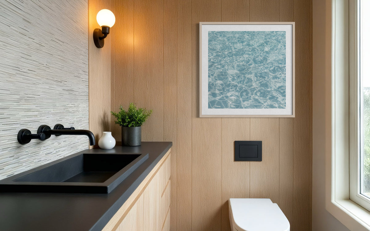 Wood-paneled bathroom with a black Refresh sink and sunlight reflecting in the space on a summer afternoon.