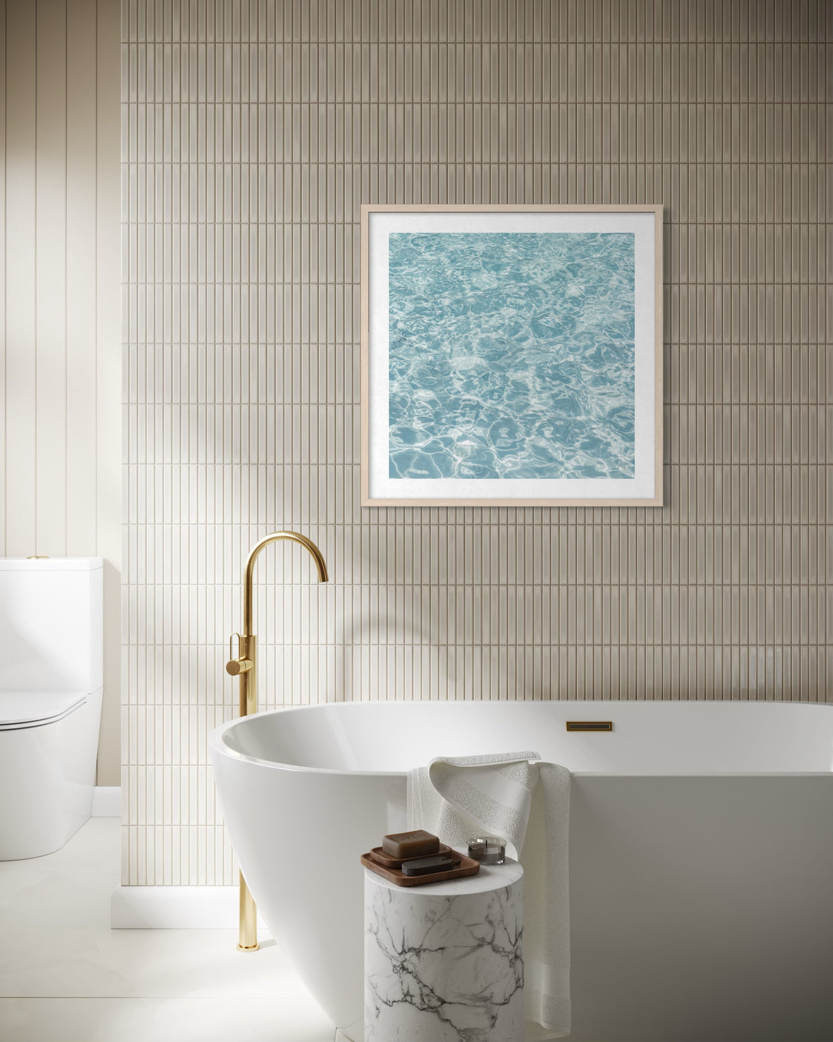 White bathtub with gold faucet and rippling water reflections on tiled wall in a modern bathroom.