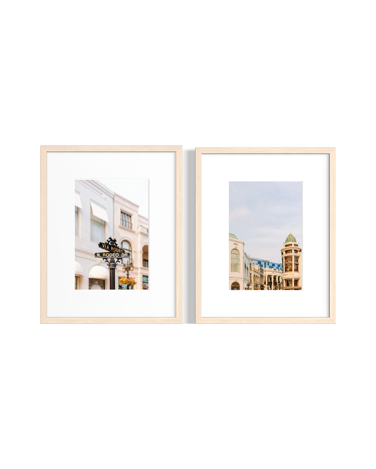Two framed pastel city scene prints of Los Angeles hang side by side on a white wall.