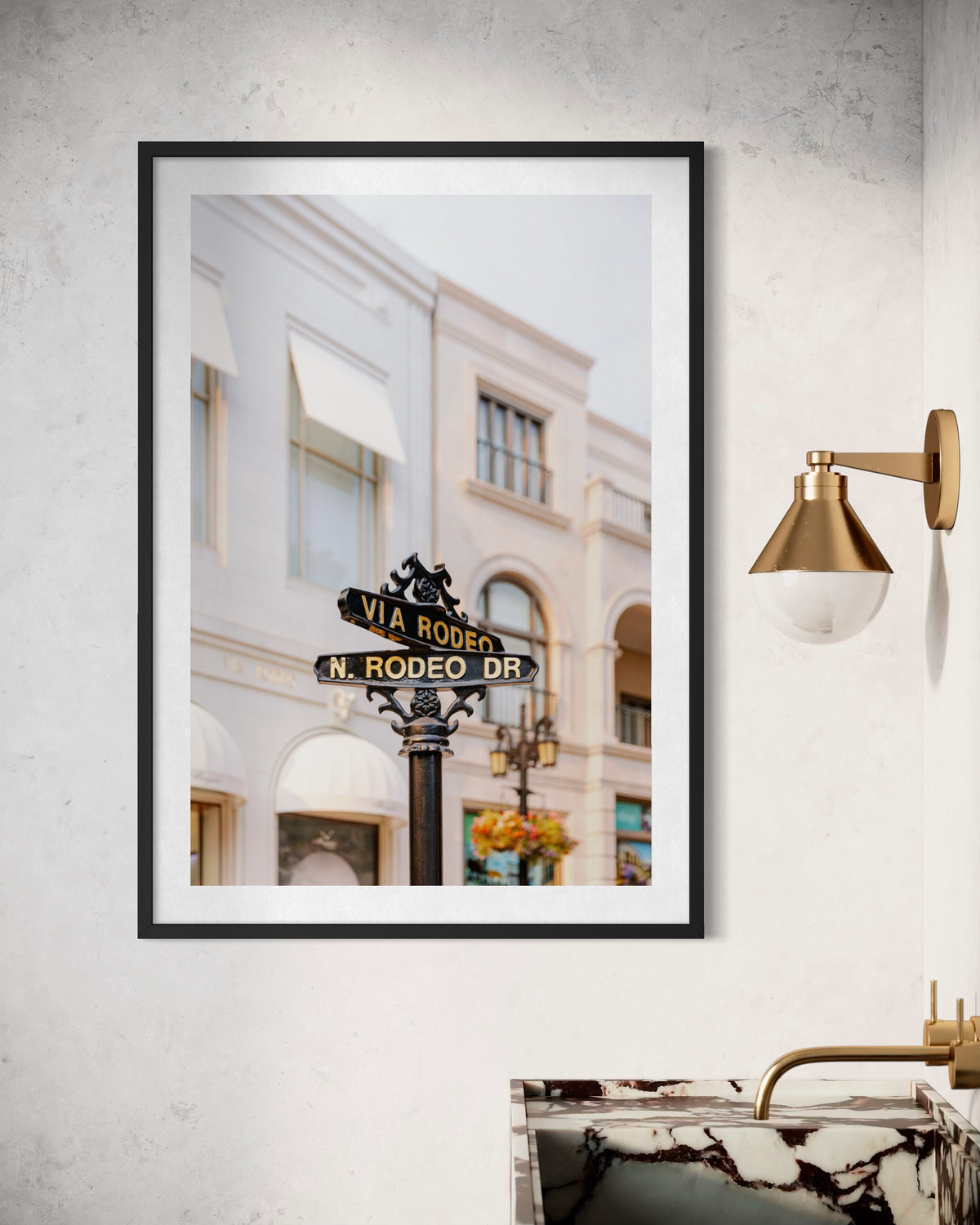 Rodeo Drive street sign above a marble sink against a light wall, photographed in Beverly Hills.