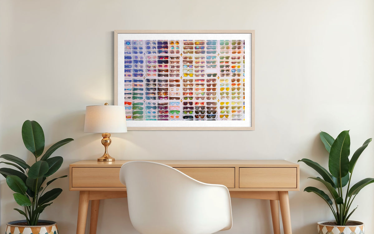 White desk, chair, lamp, two potted plants, and “Shades of Summer” art on a neutral wall.