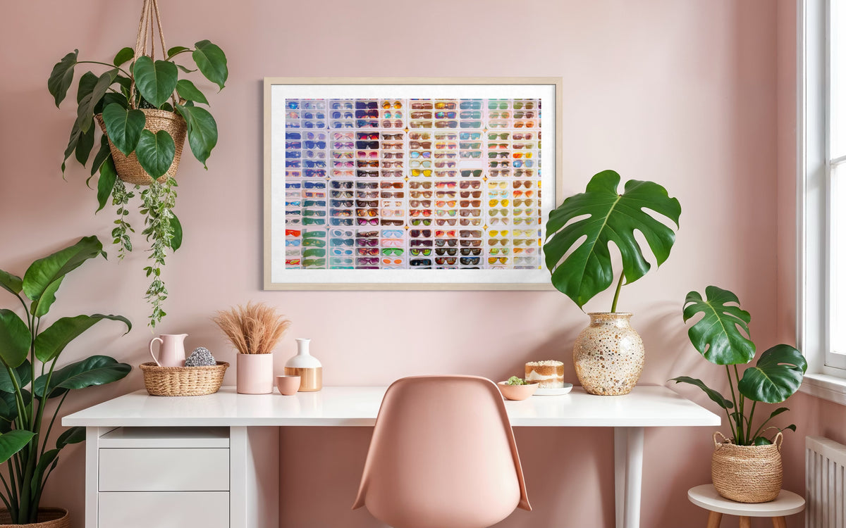 Pink home office with plants, white desk, and “Shades of Summer” print from the Refractions Collection on the wall.
