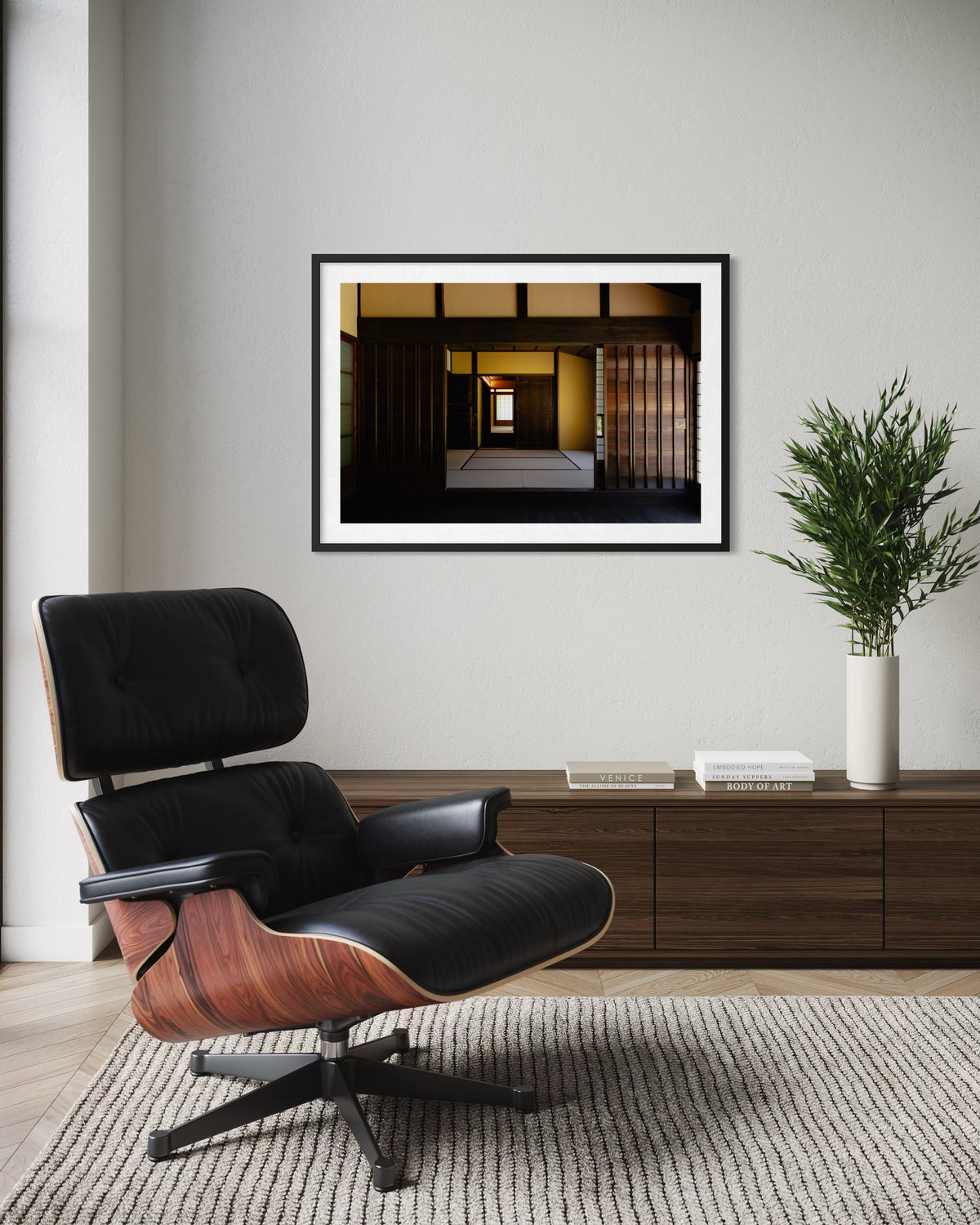 Deep wood lounge chair and sideboard under warm lighting at Shōya House, Tokyo. Minimalist interior photograph.