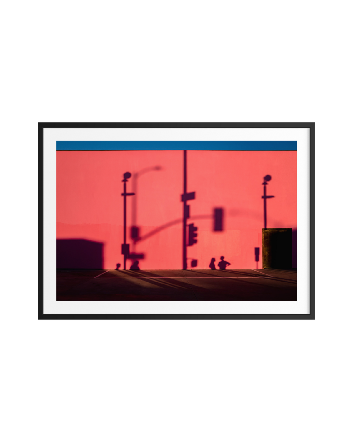 Shadows of two people against a pink wall with traffic light shapes in Los Angeles on a sunny day.