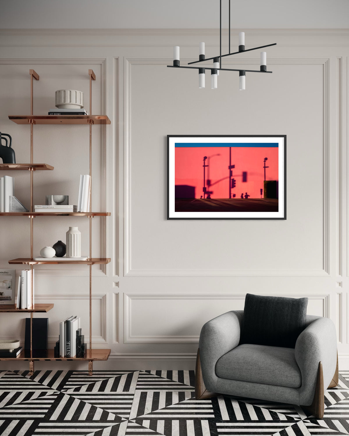 Grey chair and geometric rug in front of “That Pink Wall” red Los Angeles cityscape photograph.