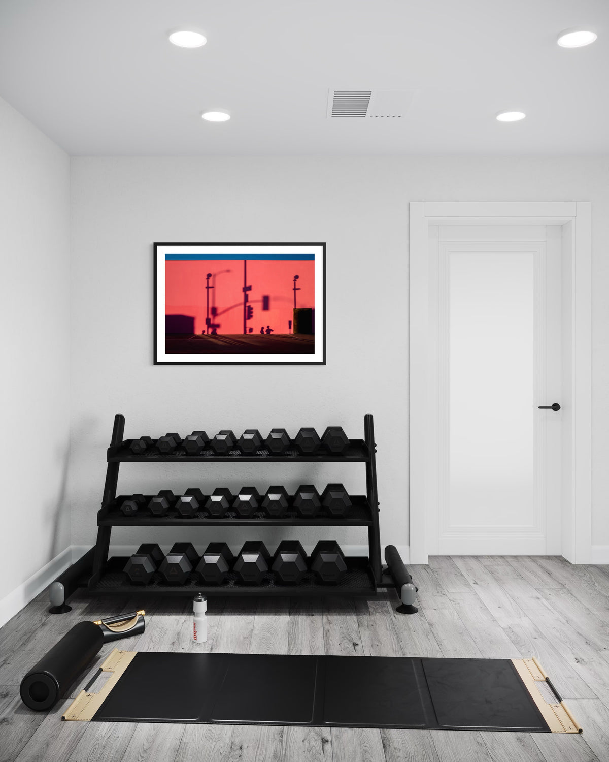 Dumbbells, yoga mat, water bottle, foam roller, and That Pink Wall art arranged against a plain white wall.