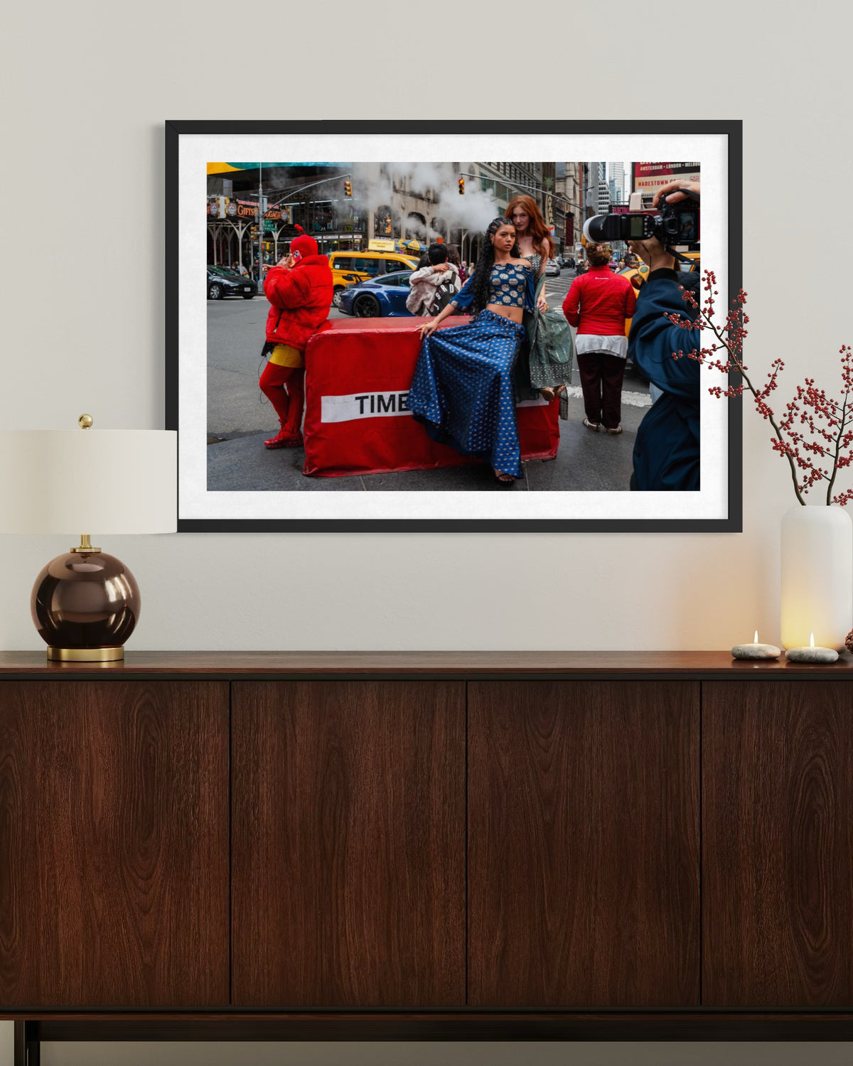 Framed street photo of Times Square above a dark wood cabinet with modern decorative accents in a room setting.