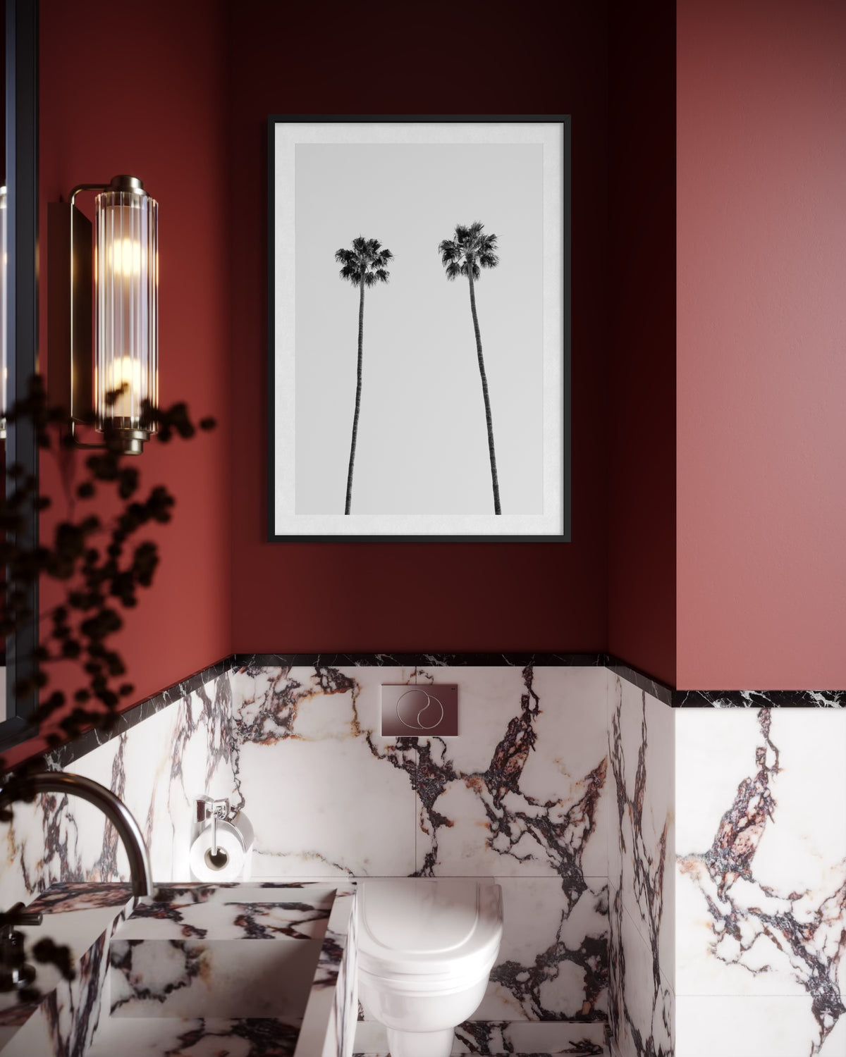 Maroon bathroom with marble walls, toilet, sink, and “Twin Palms” artwork above the toilet.