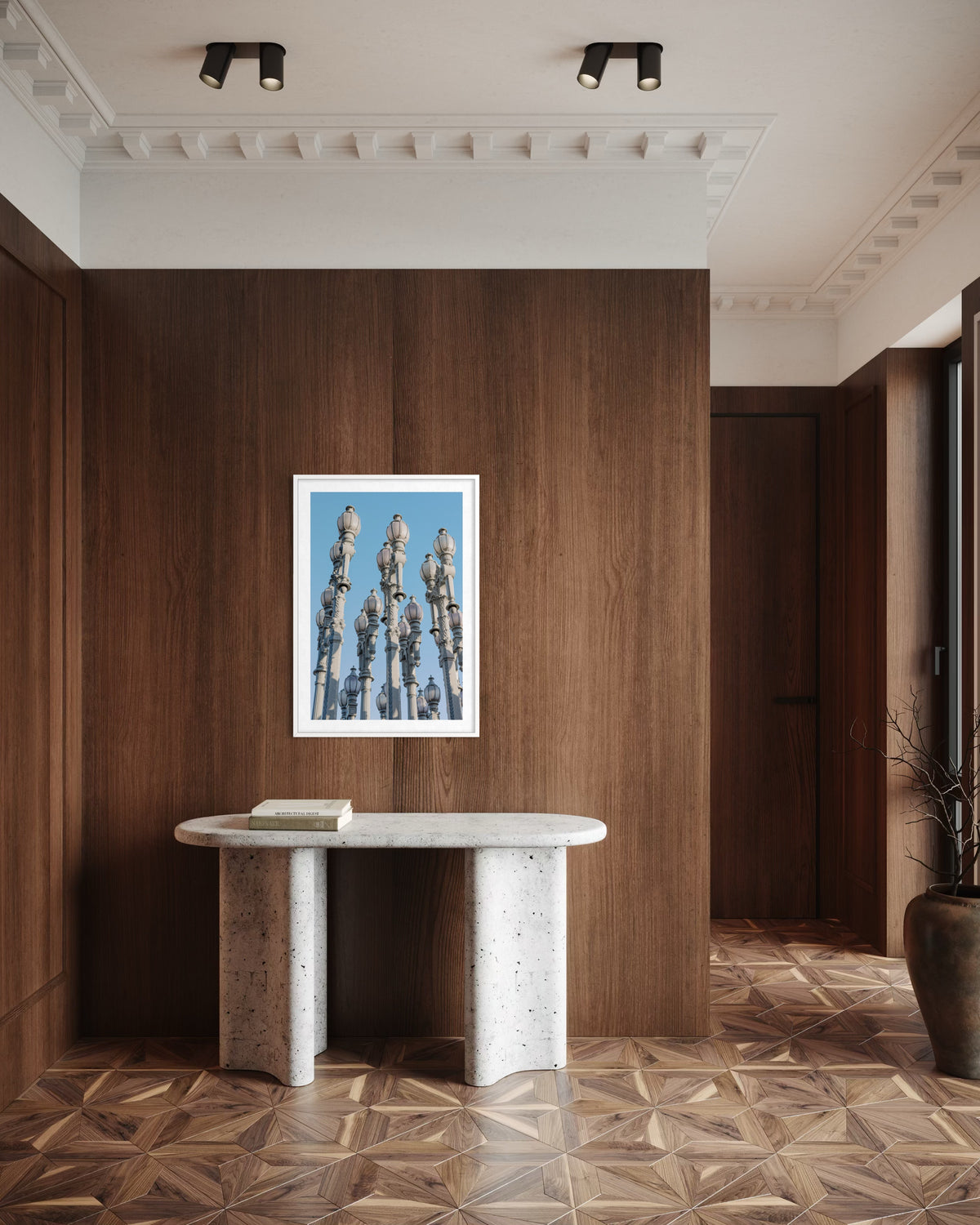Wood-paneled hallway with stone console, book, and framed “Urban Lights” Los Angeles artwork statue.