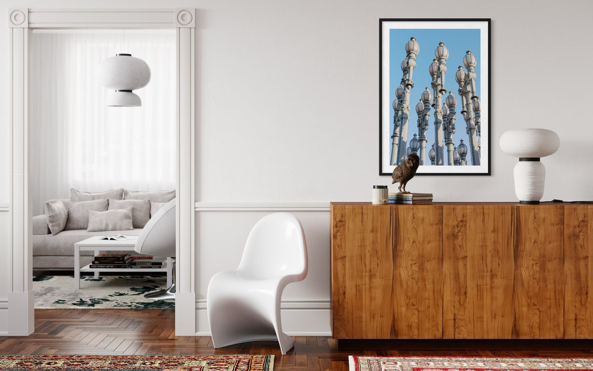 Los Angeles living room featuring white walls, wooden cabinet, artwork, and Urban Lights-style outdoor lamps.