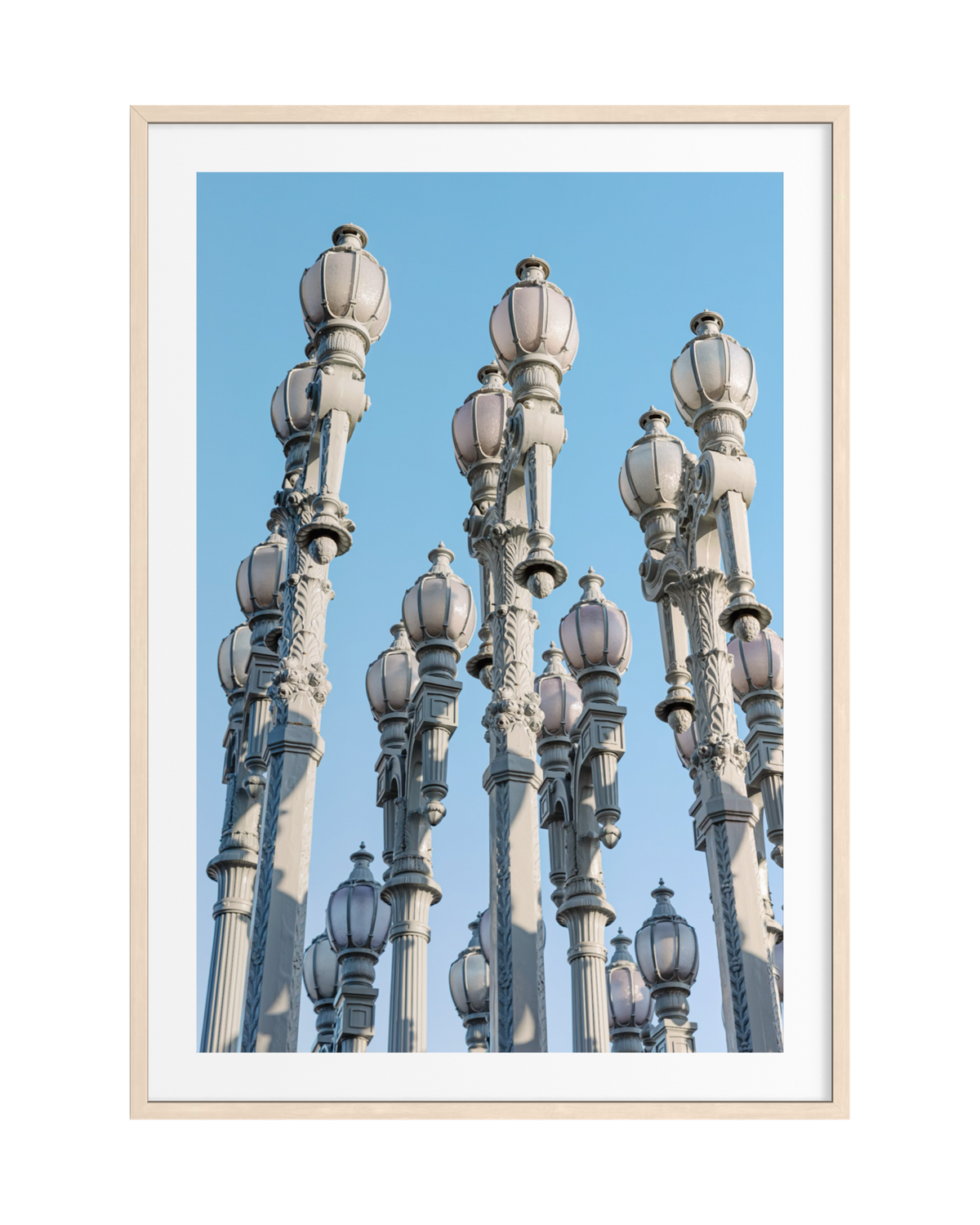 Urban Light installation in Los Angeles stands beneath a clear blue sky, seen in this framed photography print.